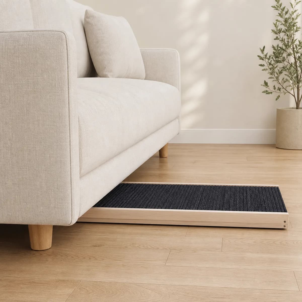 Flach zusammengeklappte Hunderampe unter einem Sofa